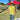 Man wearing a colorful shirt and straw hat standing in front of a red tent outdoors.