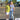 Two people standing together on a road with a casual setting, one wearing a colorful shirt and the other in a white t-shirt with text.