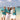Four people in matching outfits on a beach with a boat in the background
