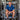 Man in a blue shirt sitting among industrial brewing equipment