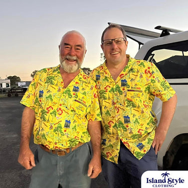 Two men wearing yellow patterned shirts standing next to a vehicle with 'Island Style Clothing' branding.